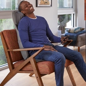 man sitting in massage cushion