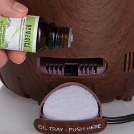 pouring essential oil into TotalComfort 2-in-1 Warm and Cool Humidifier