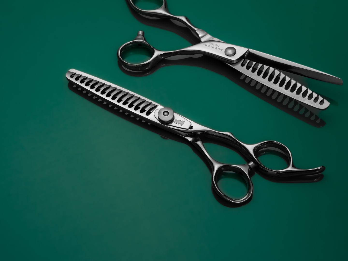 silver right handed scissors with black "N" logo and 20 teeth on one blade on a green background