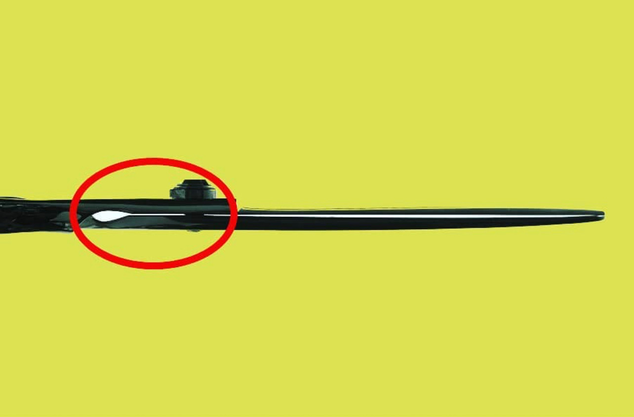 a black right handed scissor on a yellow background with a red circle around the scissors main screw showing the space between the blades
