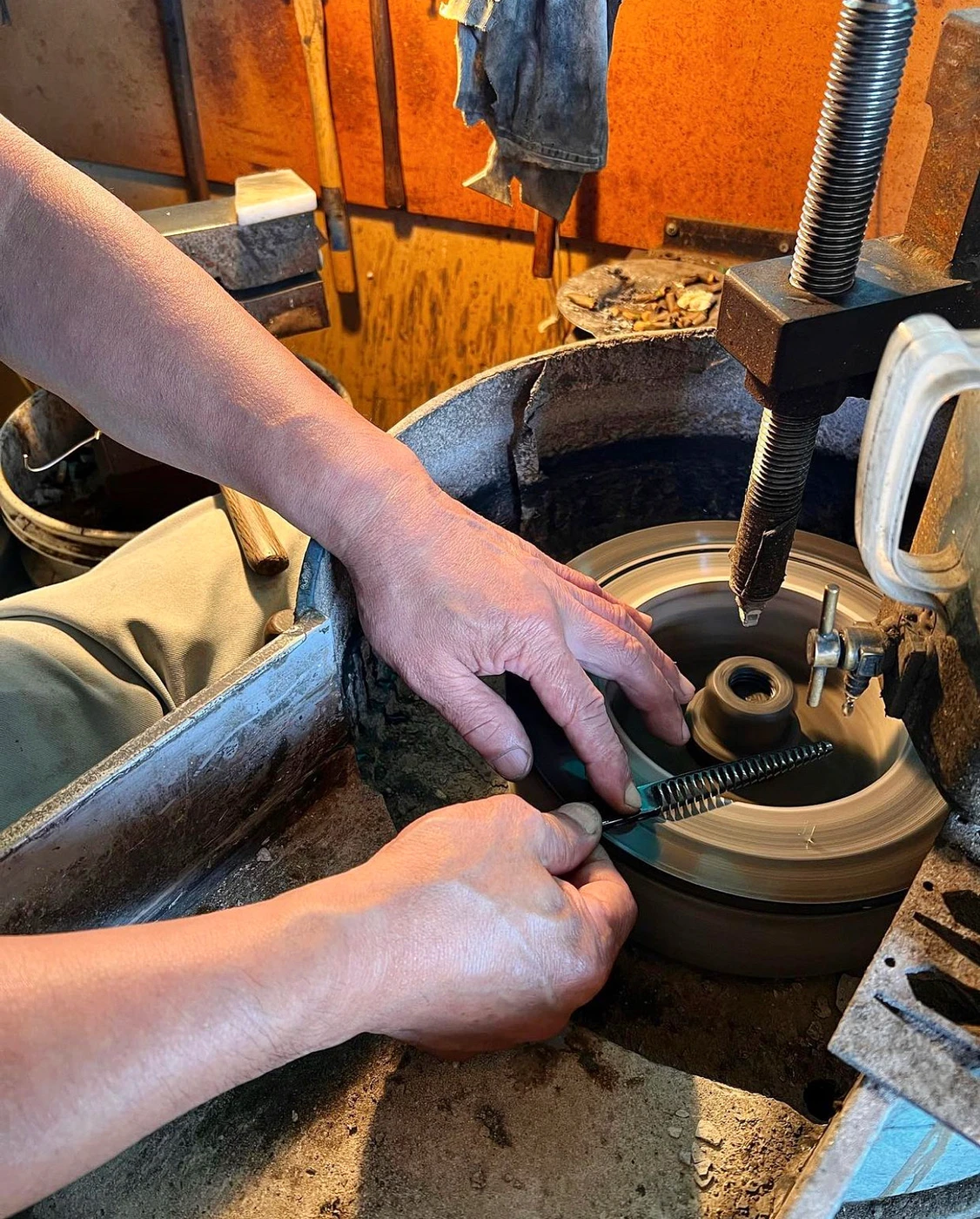 a man holding a scissor down on a grind wheel