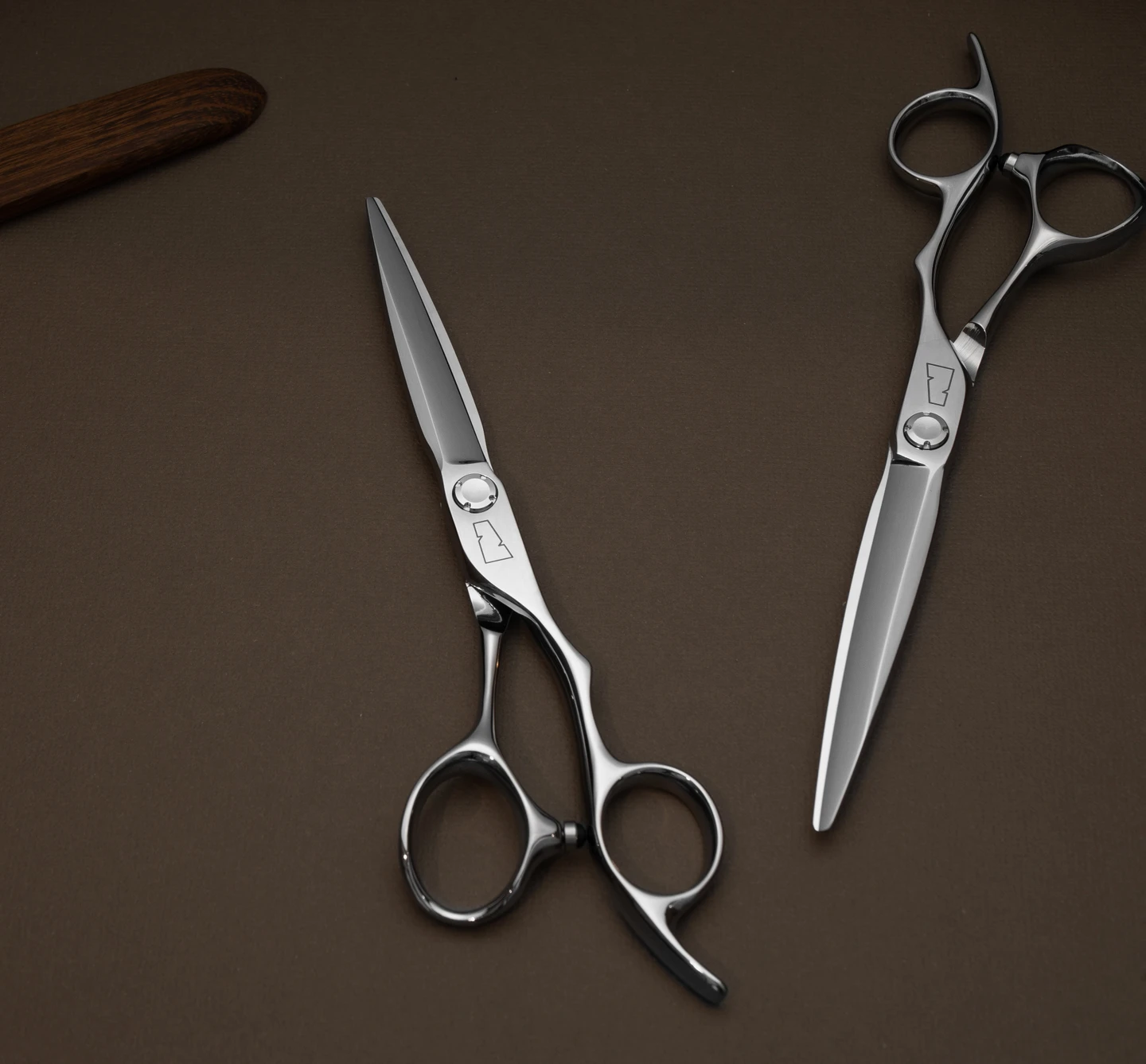 silver colored right handed hair scissor with black "N" logo on a brown background