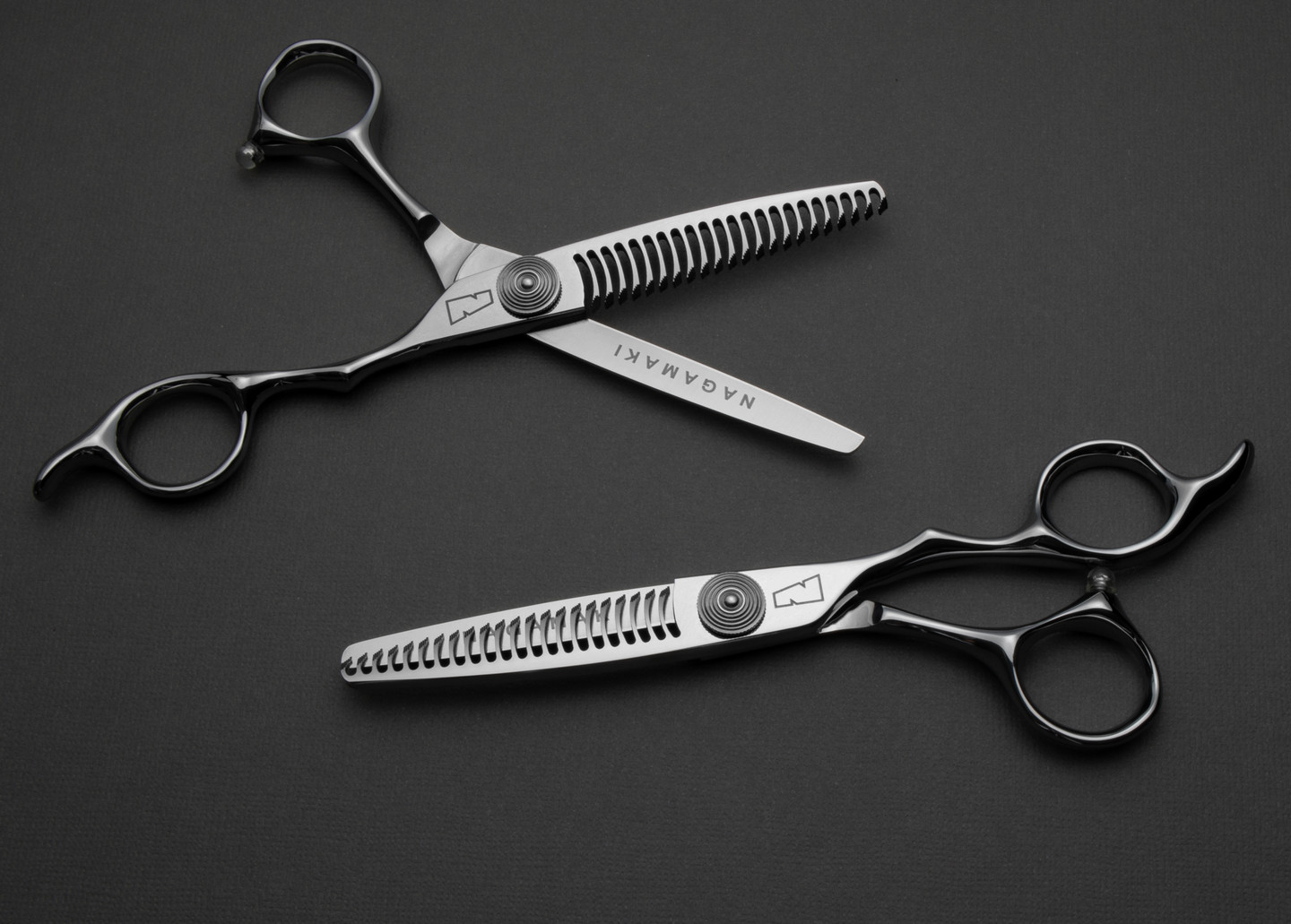 silver colored right handed hair scissor with black "N" logo and 22 teeth on one blade on a dark grey background