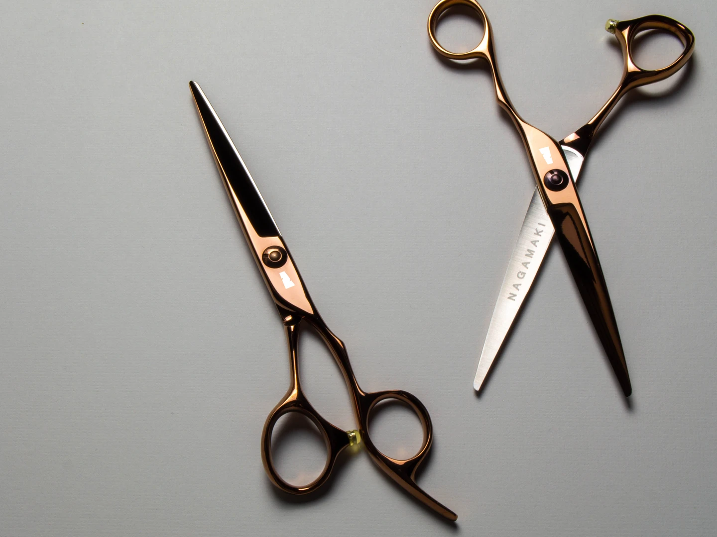 copper colored right handed hair scissor with white "N" logo on grey background