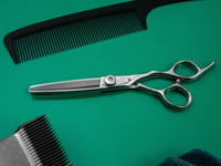 silver right handed scissors with black "N" logo and 40 teeth on one blade on a green background