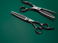 silver right handed scissors with black "N" logo and 20 teeth on one blade on a green background