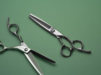 silver right handed scissors with black "N" logo and 35 teeth on one blade on a green background