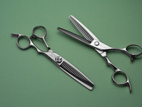 silver right handed scissors with black "N" logo and 26teeth on one blade on a green backgorund