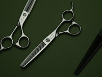 silver right handed scissors with black "N" logo and 35 teeth on one blade on a green background