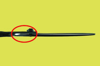 a black right handed scissor on a yellow background with a red circle around the scissors main screw showing the space between the blades.