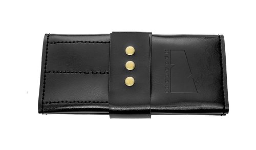A black leather scissor case with gold buttons and the Nagamaki logo on ther front