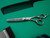 silver right handed scissors with black "N" logo and 40 teeth on one blade on a green background