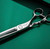 silver right handed scissors and 40 teeth on one blade on a green background