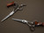silver colored right handed hair scissor with black "N" logo and the word "judan' inscribed in black on the blade on a brown background