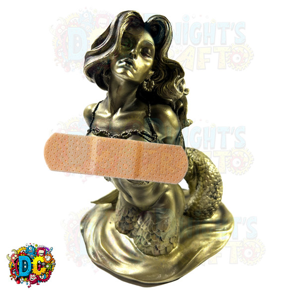 half nude sexy and seductive mermaid figurine coming out of the water