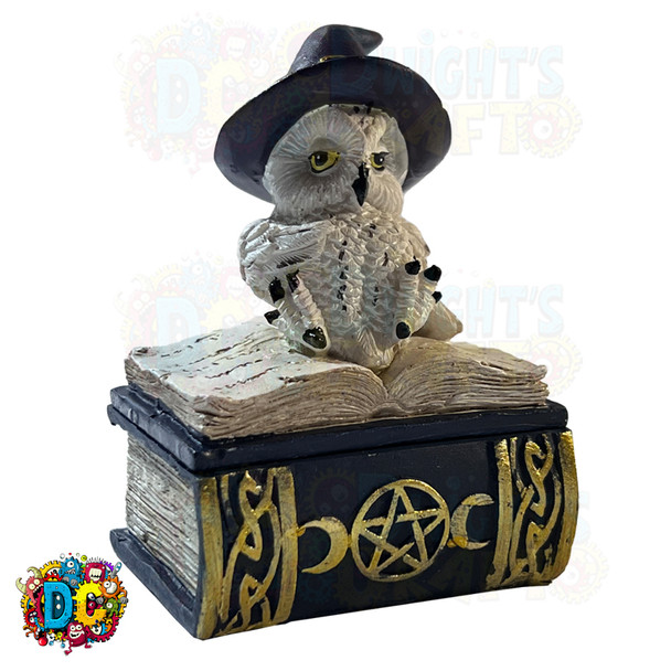 A snow owl figurine donning a witch's hat, perched atop a spell book, crafted as a small jewelry trinket box.