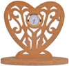 A heart shaped mini clock design on a base with a mini clock insert in the center and a scrolling design surrounding the clock on the inside of the heart.