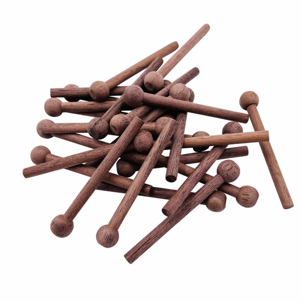 A pile of walnut pegs that are included in a package.