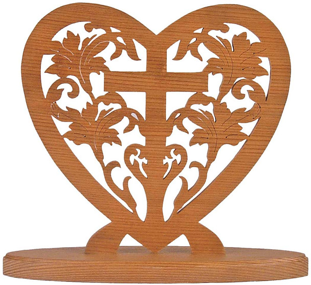 A heart-styled scroll saw piece with a cross and flowers in the center of it on a wooden base after using our Four Mini Hearts Clock Plan.