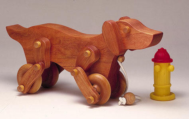 This is how your finished toy will look when using our Milo The Dog Toy Woodworking Plan
This dog is built with cherryand is standing beside a fire hydrant.
