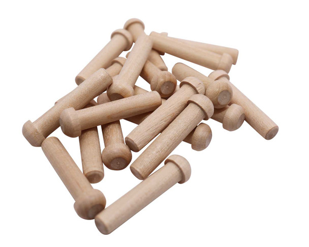 A pile of wood toy axle pegs in different directions.