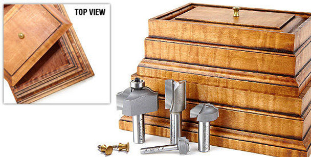  The Amana Stacking Boxes 4 Piece Set features boxes behind the four router bits and two brass knobs lying in front of the set.
