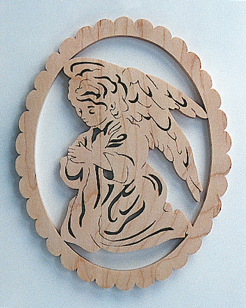A finished piece of Oak of a scroll saw cut out with an Angel in a kneeling position with her hands crossed, in an oval frame.