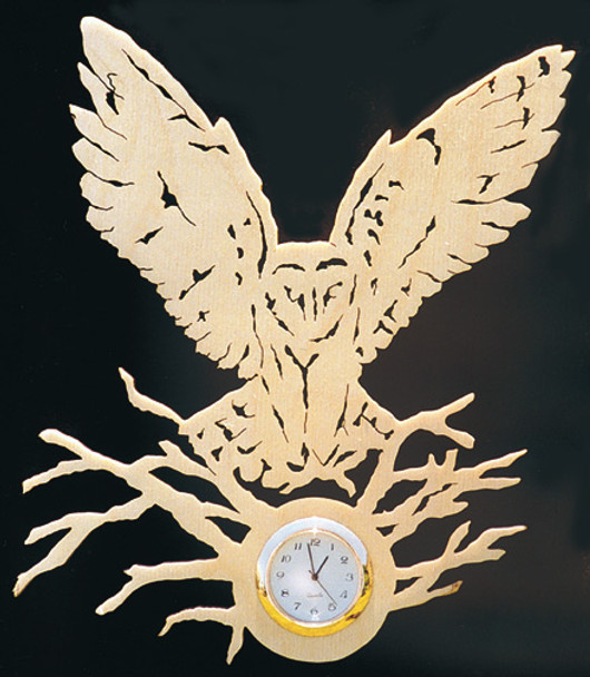 Finished cut out of an owl with wings spread landing on branches on a piece of Oak using the Barn Owl Clock Pattern.
