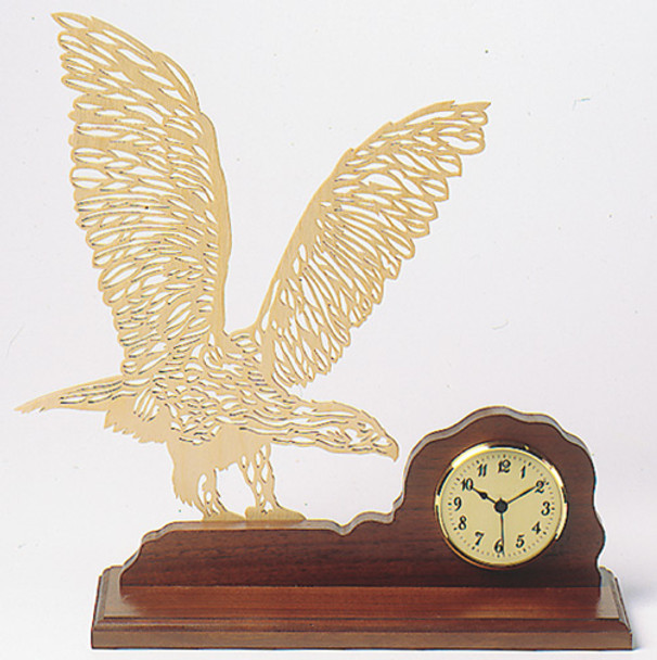 A silhouette of a bird with its wings spread and a clcok insert on the wood base.
