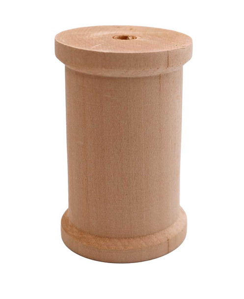 An upright large basswood spool.
