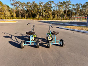 "Giant trikes lined up on a track at a corporate picnic challenge"