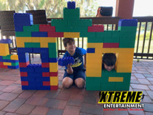 "Kids playing with giant building blocks at an outdoor event"