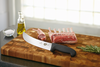 A 10" Cimeter Knife being used to cut ribs on a cutting board