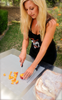 A sheet of a Stark Disposable Cutting Board being used by a woman cutting fruit