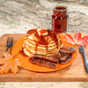 A lifestyle shot of Walton's Major Maple PSS with a stack of pancakes next to the sausage it was made with.