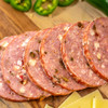 Lifestyle shot of Waltons Jalapeno Summer Sausage on a sausage cut into slices