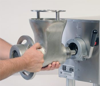A grinder head being attached to a Pro-Cut #22 Meat Grinder