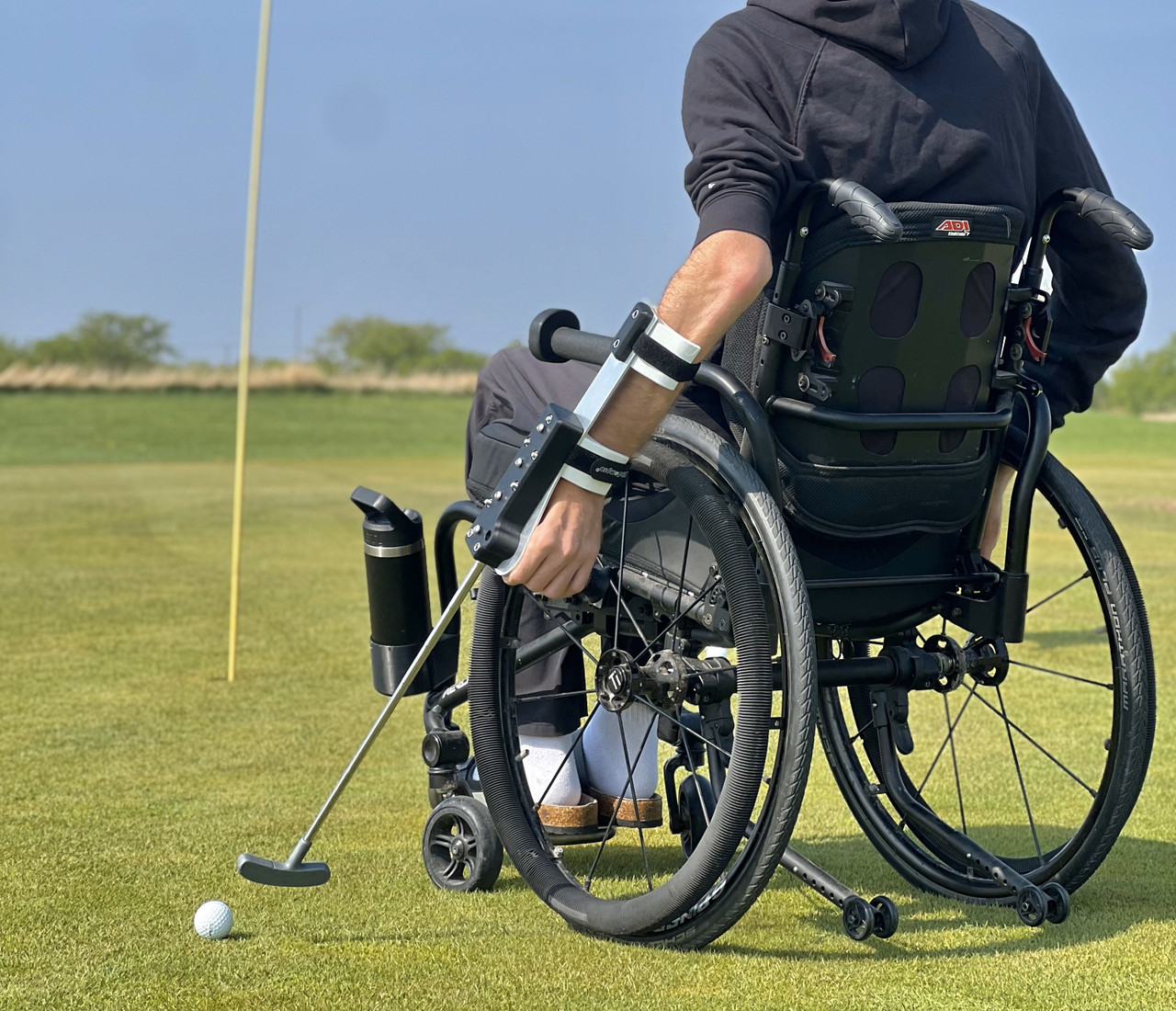 Person with C5 spinal injury using Swing Mate forearm mounted wheelchair and mobility swing. Angled back view.

