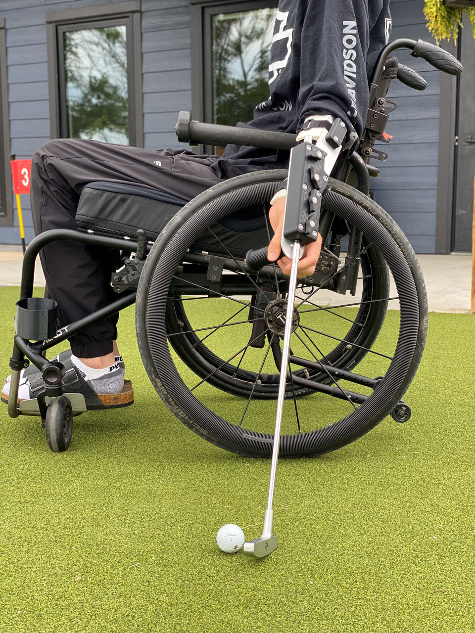 Side profile of person with C5 spinal injury using Swing Mate forearm mounted wheelchair golf aid.