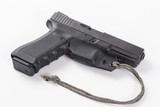 Right side of pistol in black Kydex trigger guard holster with paracord lanyard tied near front