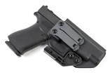 Angled rear view of black Kydex IWB holster with dual clips, claw wing and holstered pistol