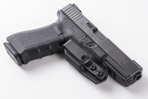Black Kydex trigger guard holster with belt clip mounted on a black pistol, angled side view