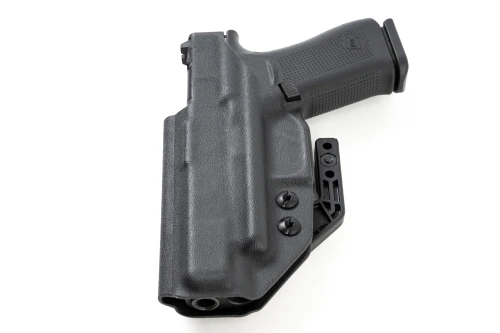 Slightly angled front view of black Kydex IWB holster, showing claw mounting screws and open muzzle end