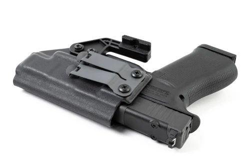 Black Kydex IWB holster lying on its side with Glock 48 MOS inserted, showing clip and claw