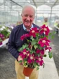Man holding flowering Elpis Clematis