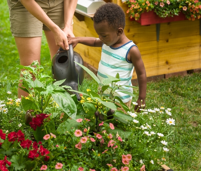 assisting-child-with-watering-garden-planter.jpg
