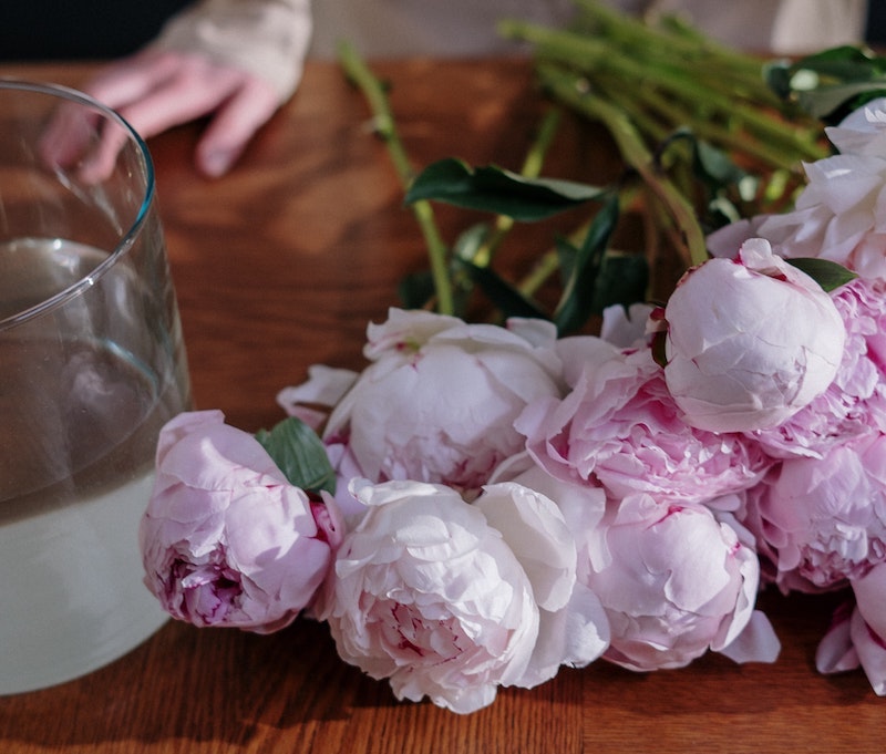 cut-peony-stems-next-to-container-of-water.jpg