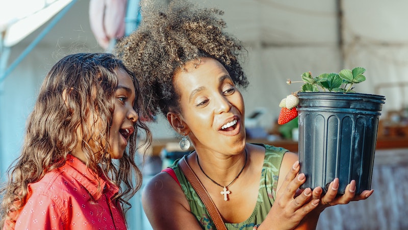 lady-and-child-looking-at-a-ripe-strawberry-in-pot.jpg