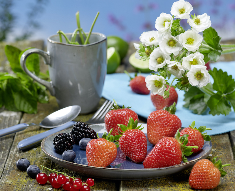 plate-of-berries-next-to-blooming-strawberry-plant.jpg