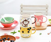 Generic Ceramic Porcelain Tableware Set Monkey, colorful animal-themed mugs and bowls with playful designs on a white table.